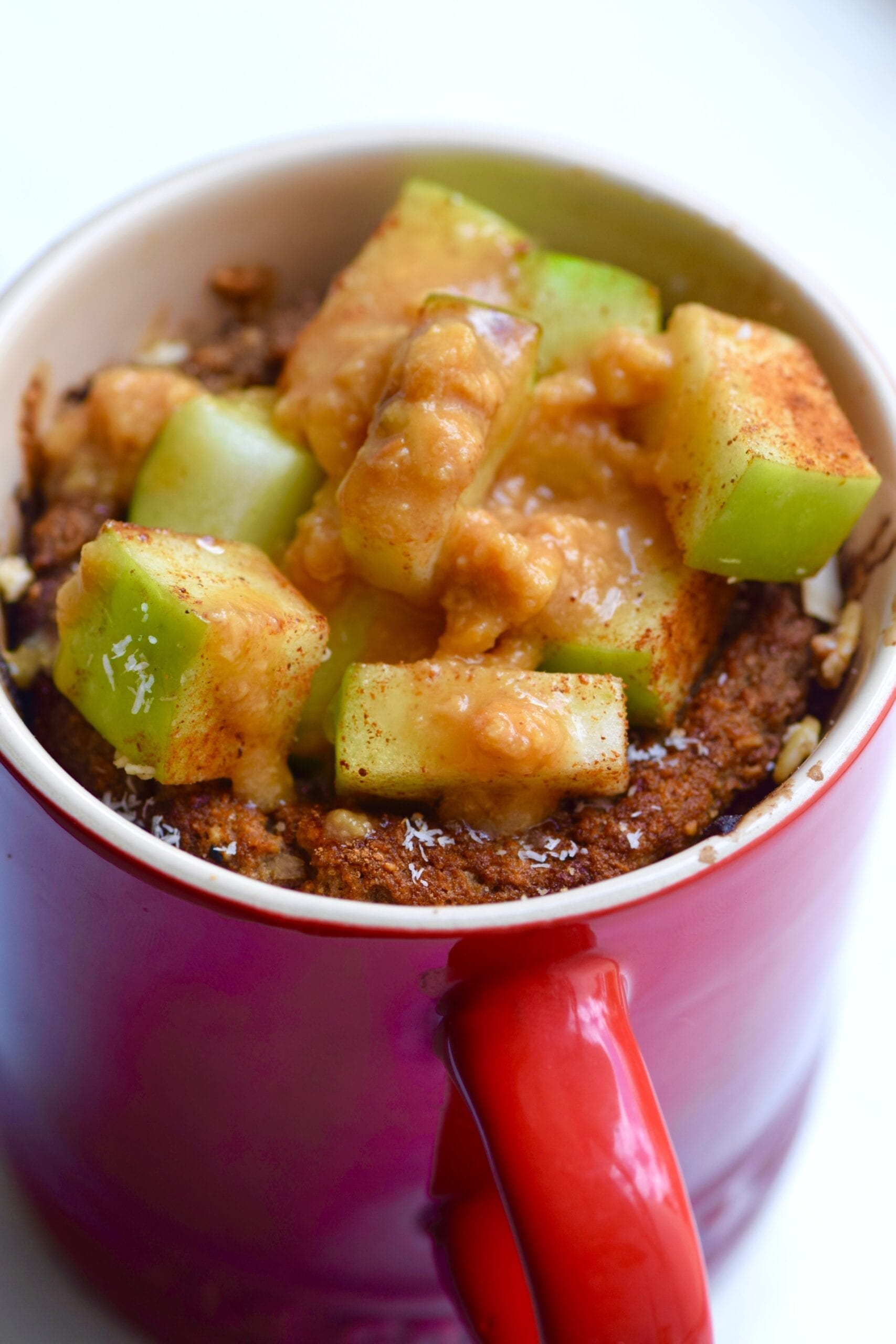Vegan apple pie mug cake topped with extra chopped apples & caramel sauce