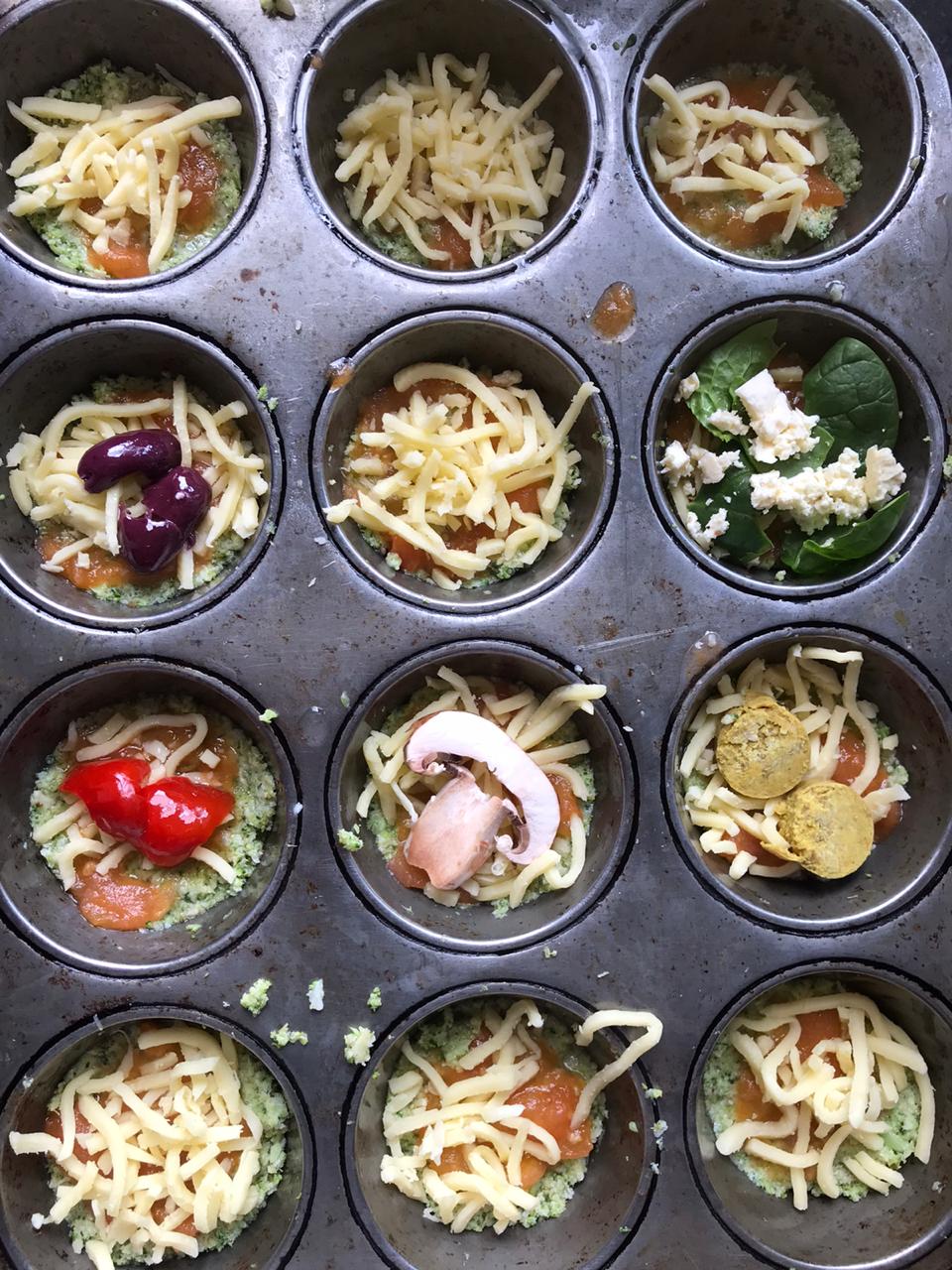 Adding toppings to cauliflower pizza in muffin tin