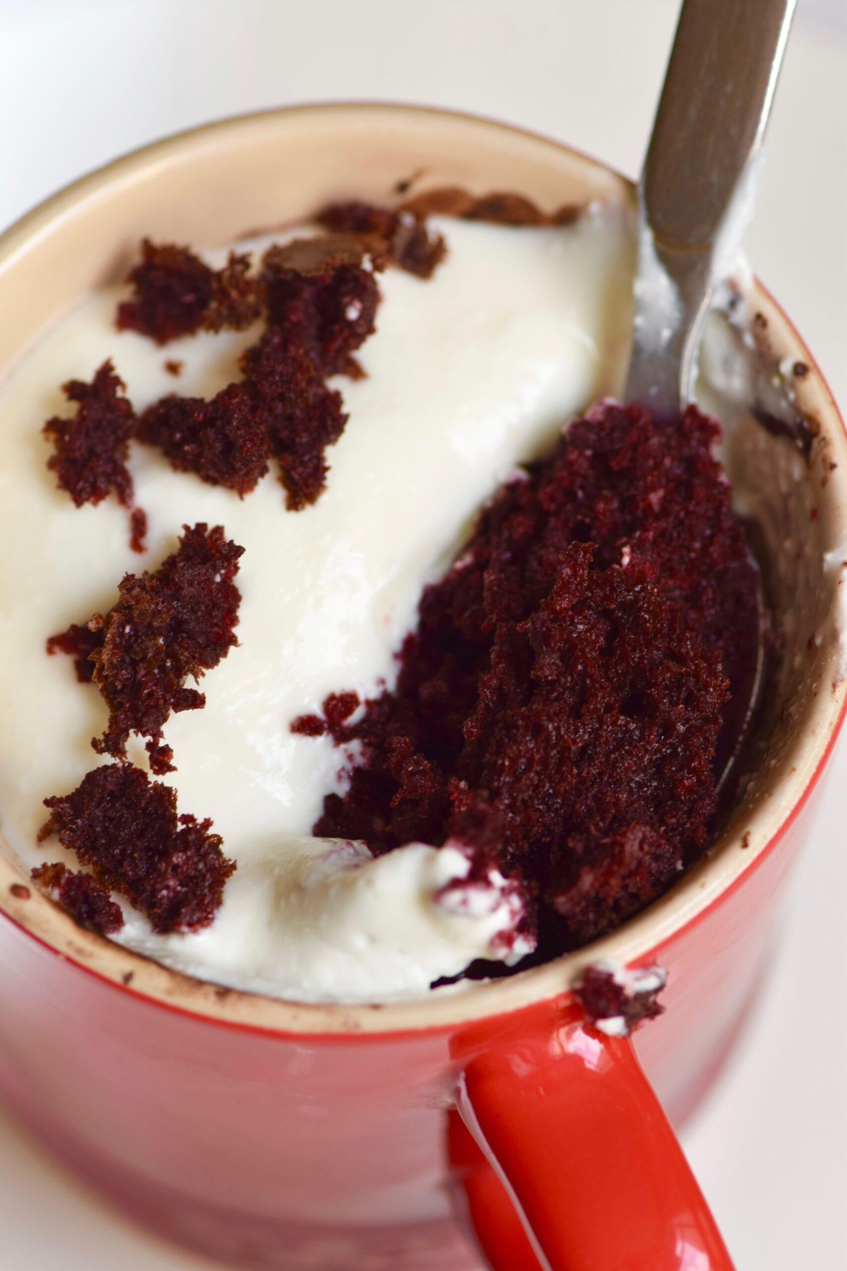 Healthy red velvet cupcake mug cake with spoon inside