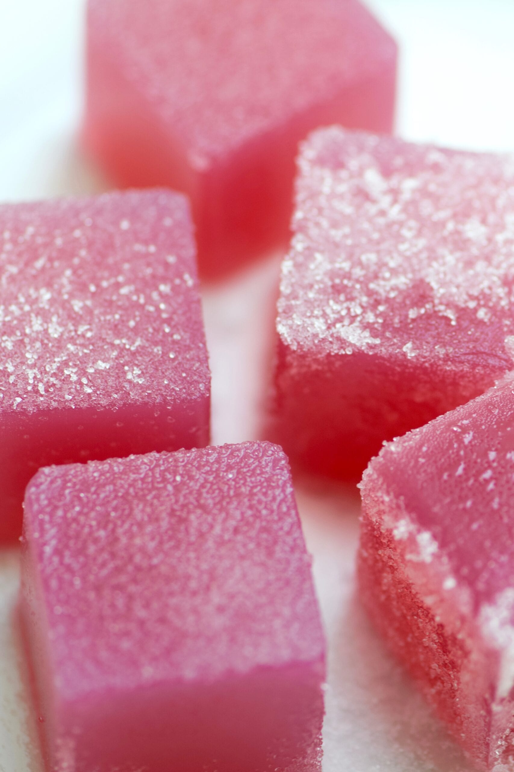 Pink sour grape gummies with a sweetener dusting