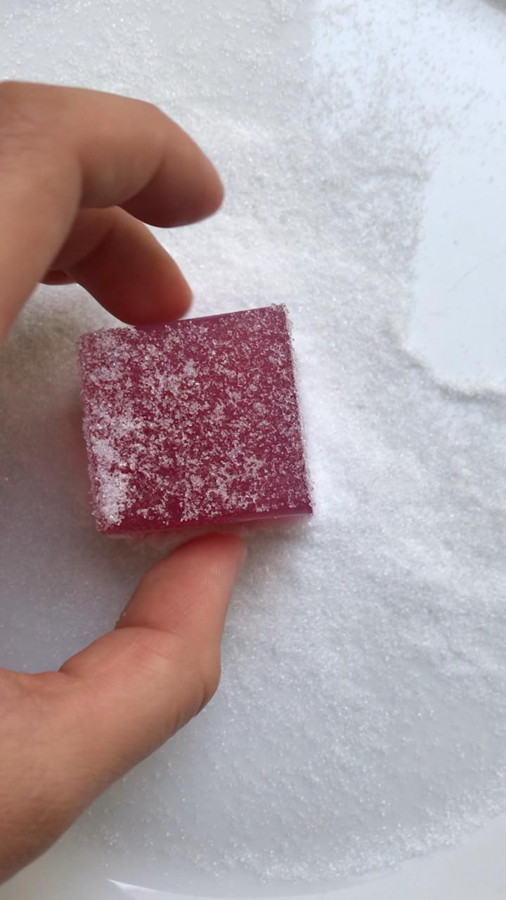 Dusting sour grape homemade gummies in sweetener