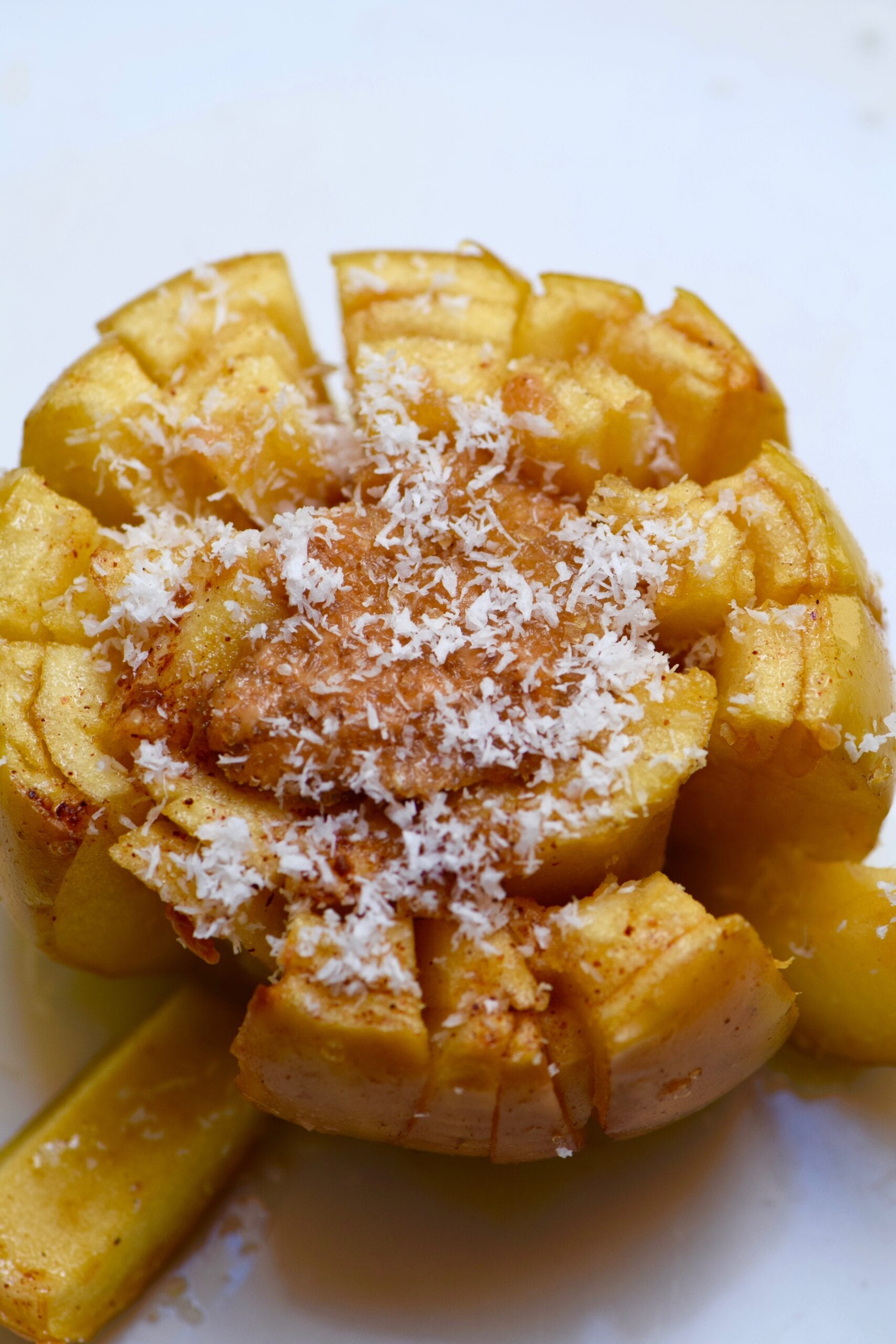 Baked blooming apple with caramel filling dusted in coconut