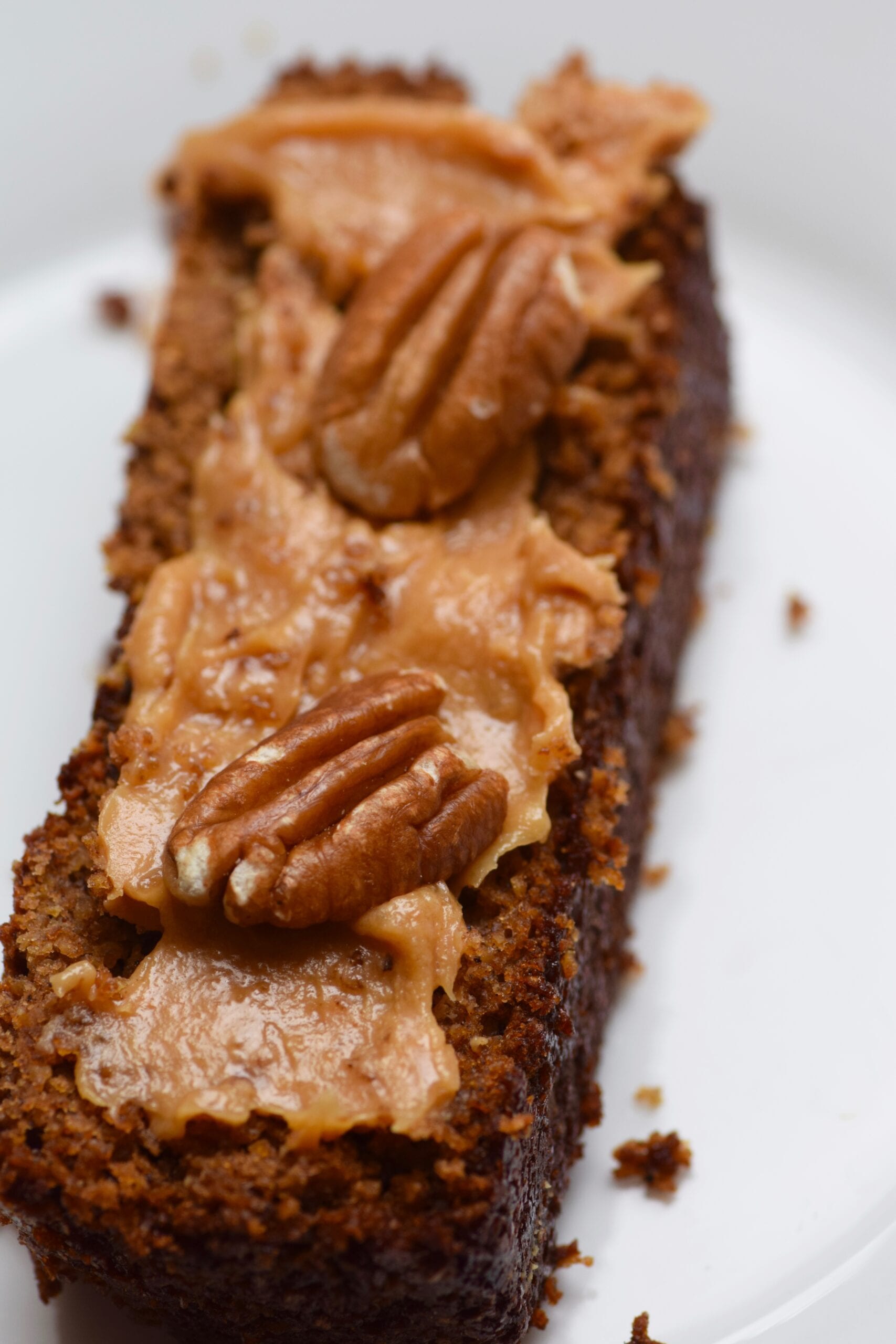 Healthy oatmeal gingerbread loaf topped with nut butter and pecans