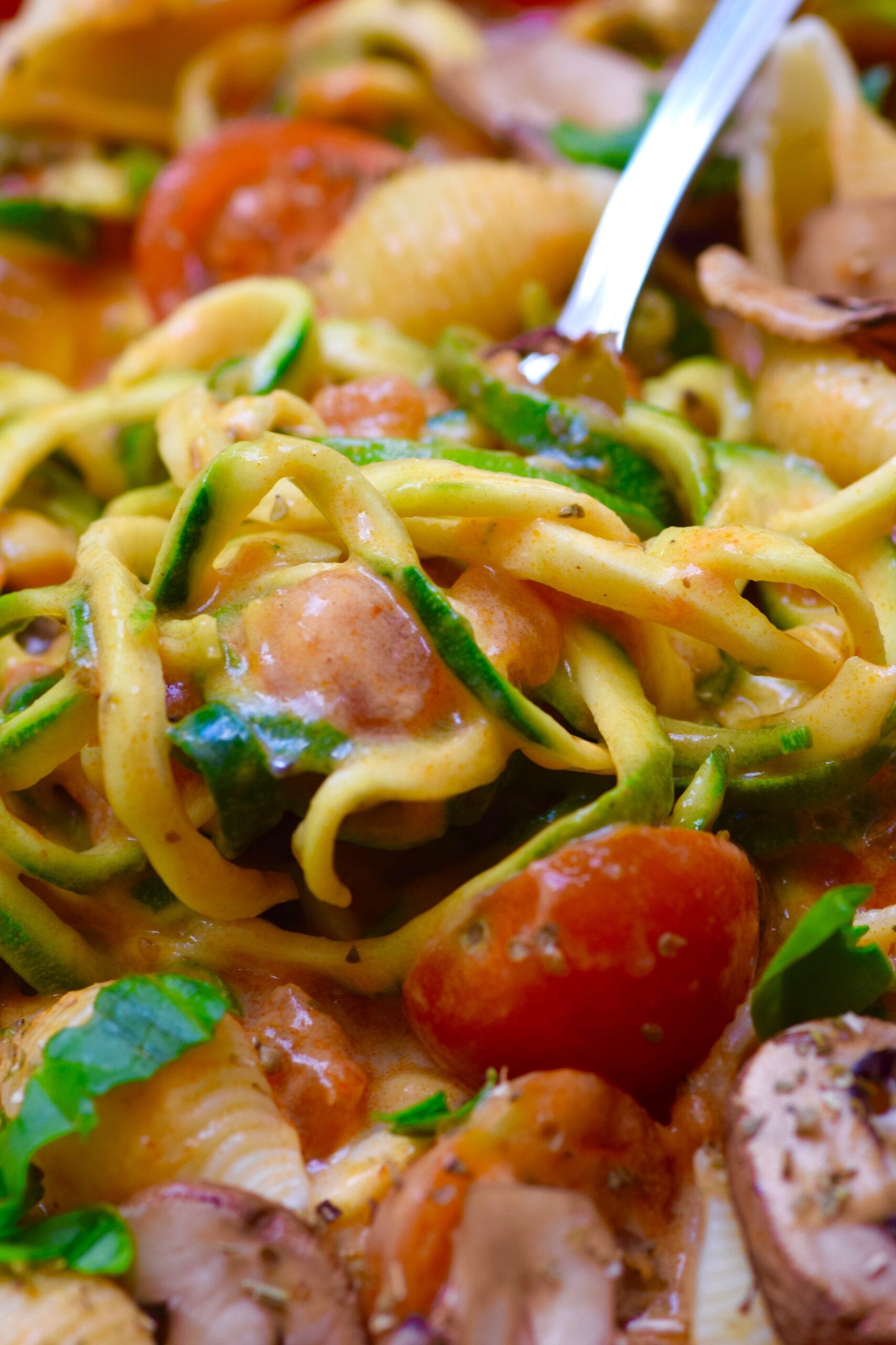 Creamy zucchini tomato pasta with a fork inside