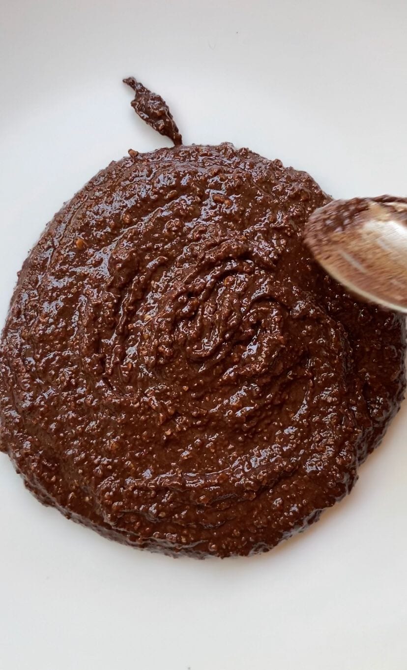 Brownie cookie dough being place on plate before baking