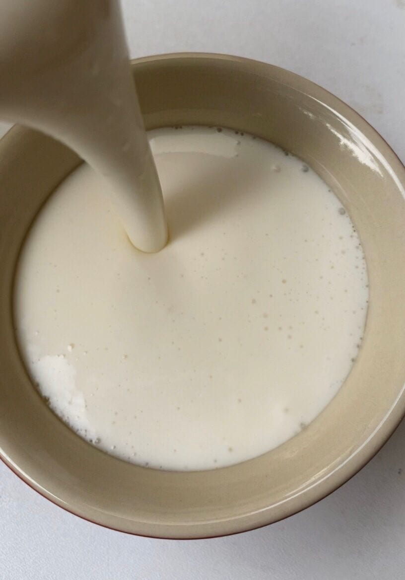 Pouring vanilla no bake cheesecake mixture into ramekin