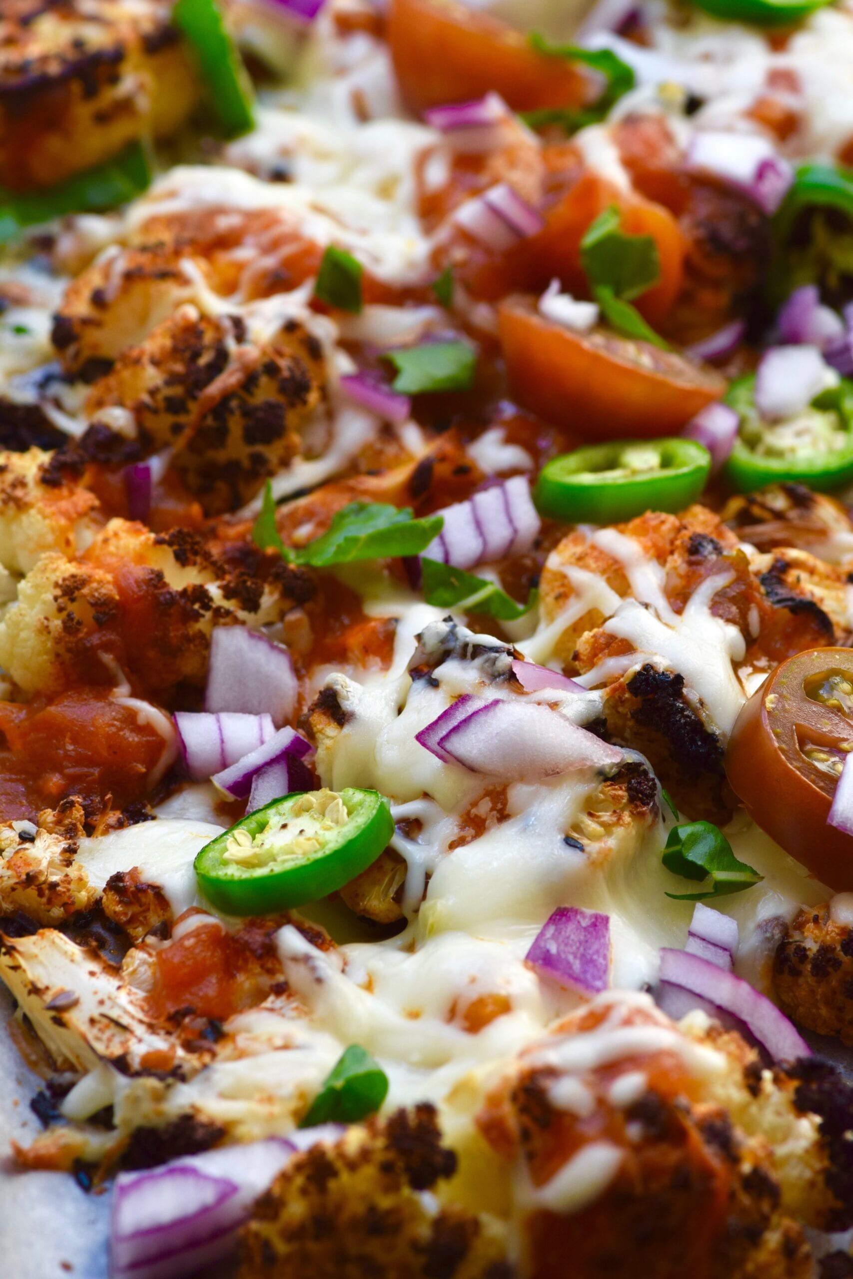 Low carb cheesy cauliflower nachos with salsa, onions, jalapeños, tomatoes 